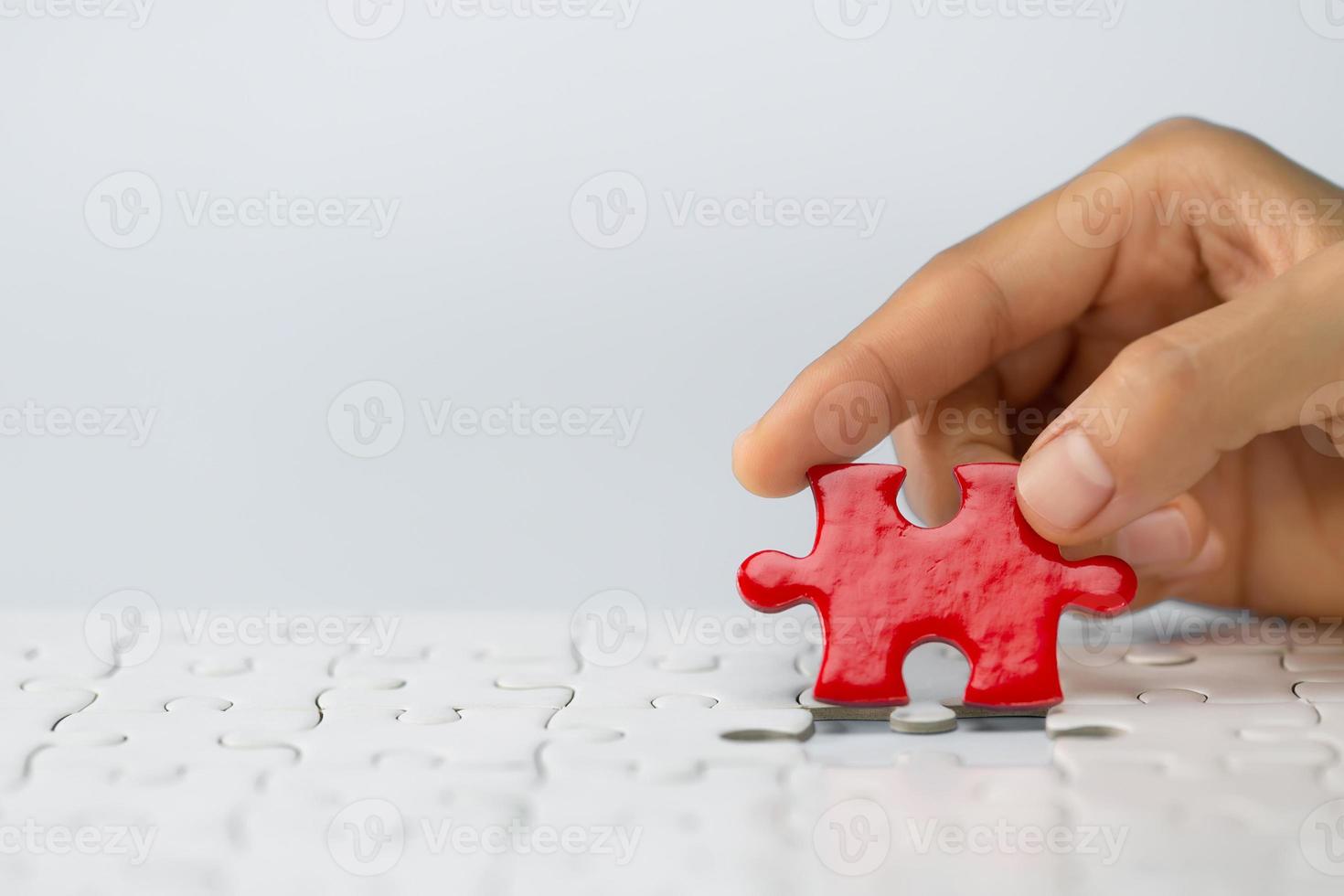 mãos humanas segurando um quebra-cabeça vermelho com solução de problema de palavra. símbolo de associação e conexão. estratégia de negócio. foto