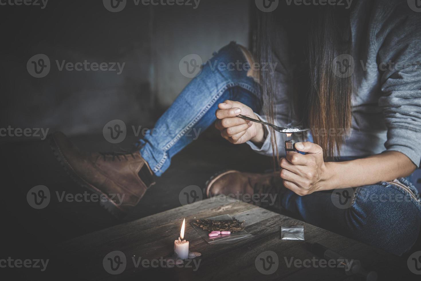 viciados em drogas no quarto escuro. viciado viciado preparando drogas com uma colher e isqueiro. pó branco e uma seringa. conceito de droga. Dia Internacional do Abuso de Drogas. foto