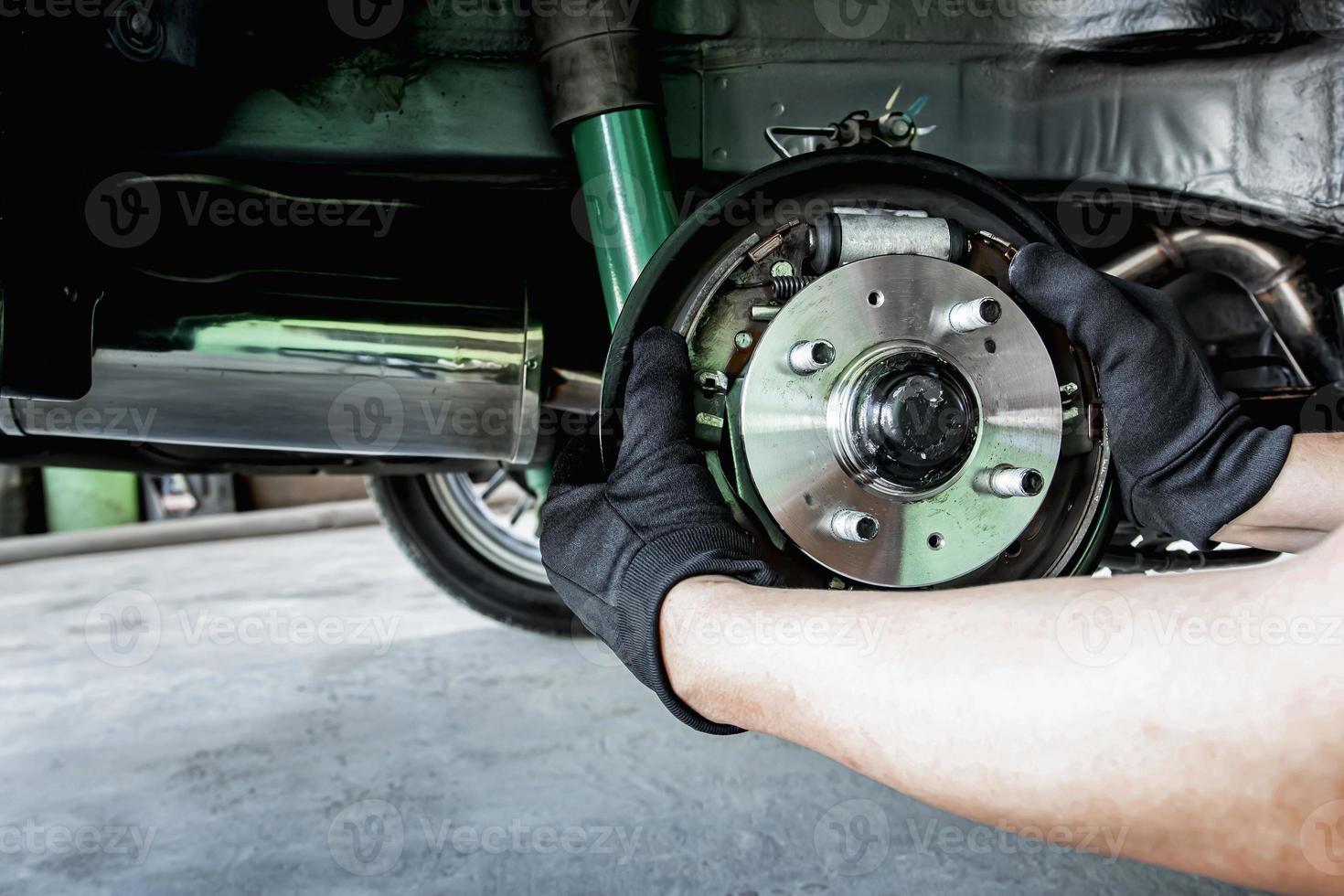 um homem muda a roda do rolamento do cubo automático do carro para o conceito de manutenção e ferramenta para serviço foto