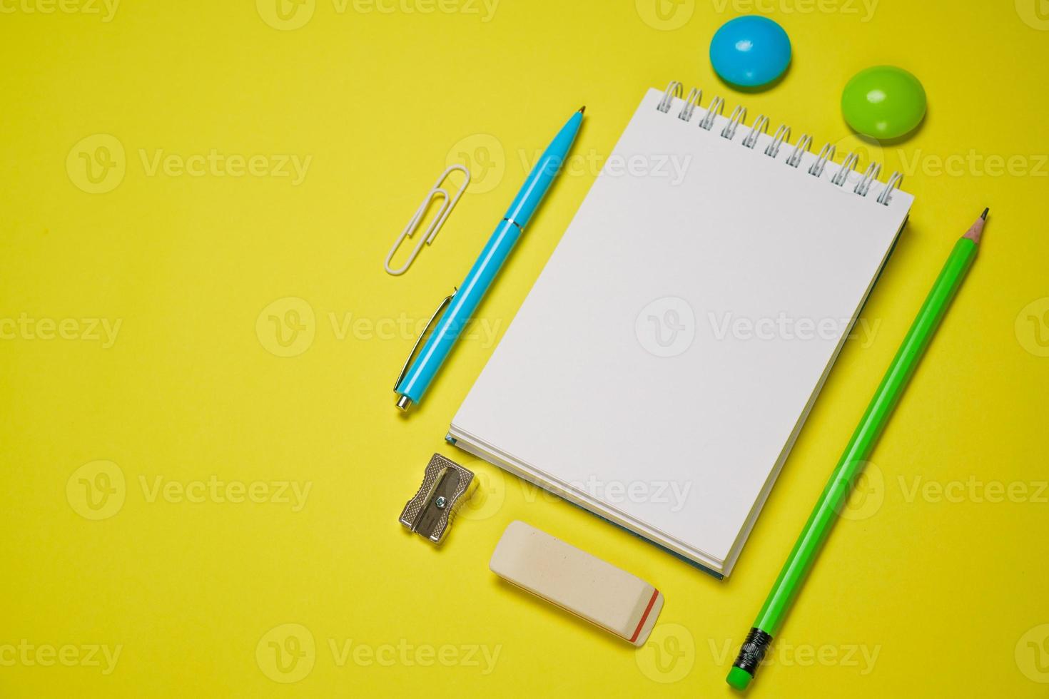 caderno e caneta em um fundo amarelo. vista superior com espaço de cópia. papelaria foto