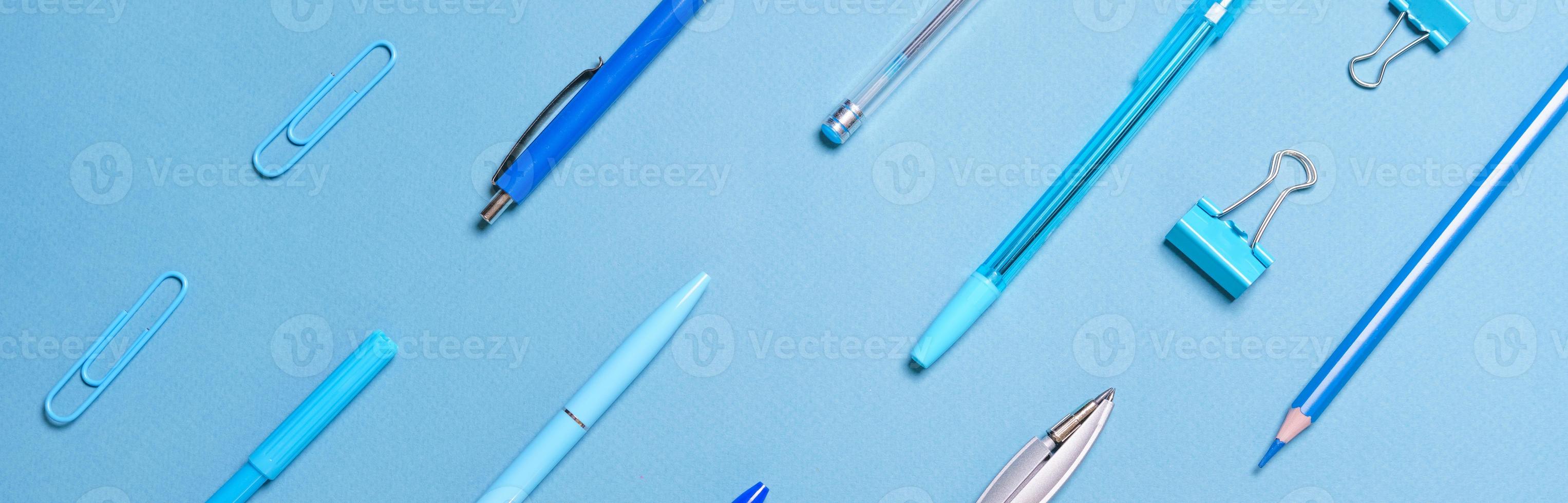 canetas lápis bússolas clipes de papel dispostos em linhas todas azuis e de fundo foto