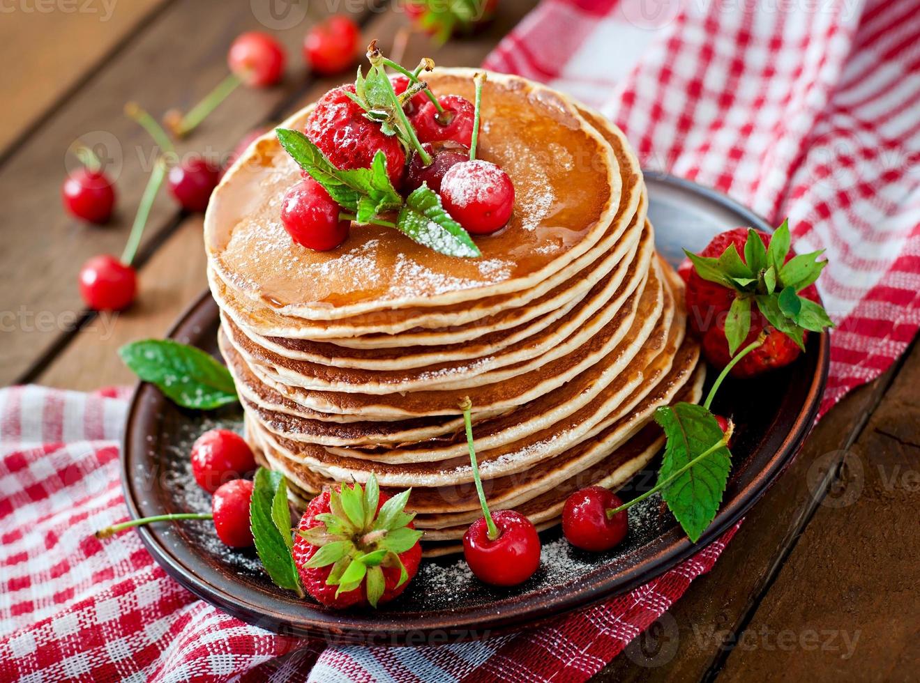 panquecas com frutas vermelhas e calda em estilo rústico foto