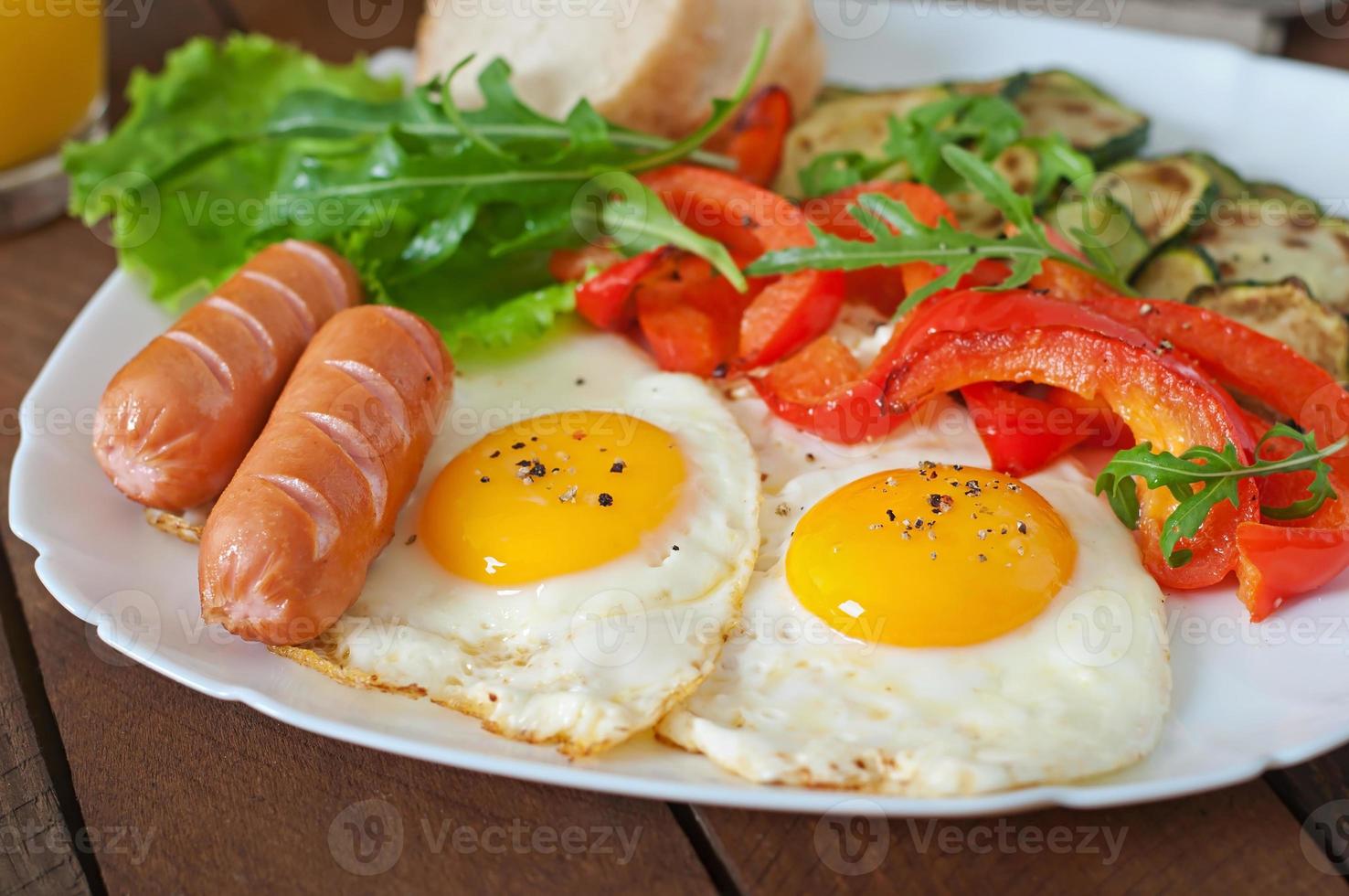 café da manhã inglês - ovos fritos, salsichas, abobrinha e pimentão foto