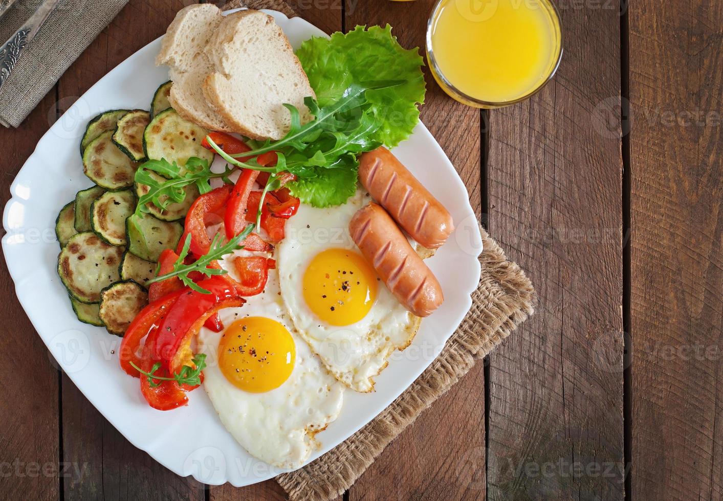café da manhã inglês - ovos fritos, salsichas, abobrinha e pimentão foto