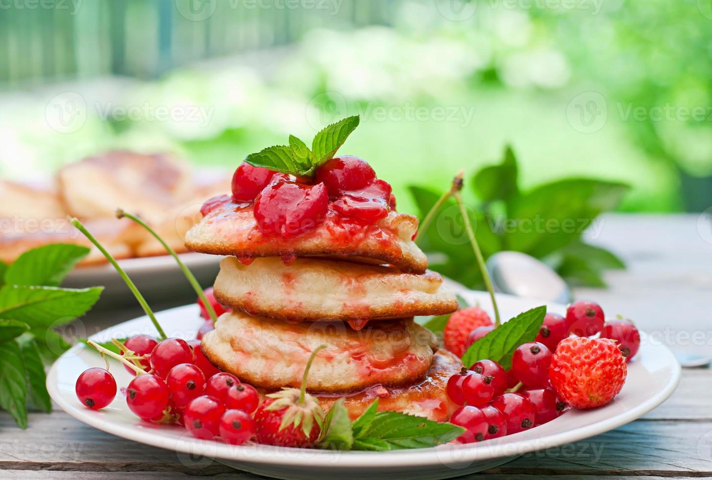 panquecas com frutas em um fundo de madeira em um jardim de verão foto