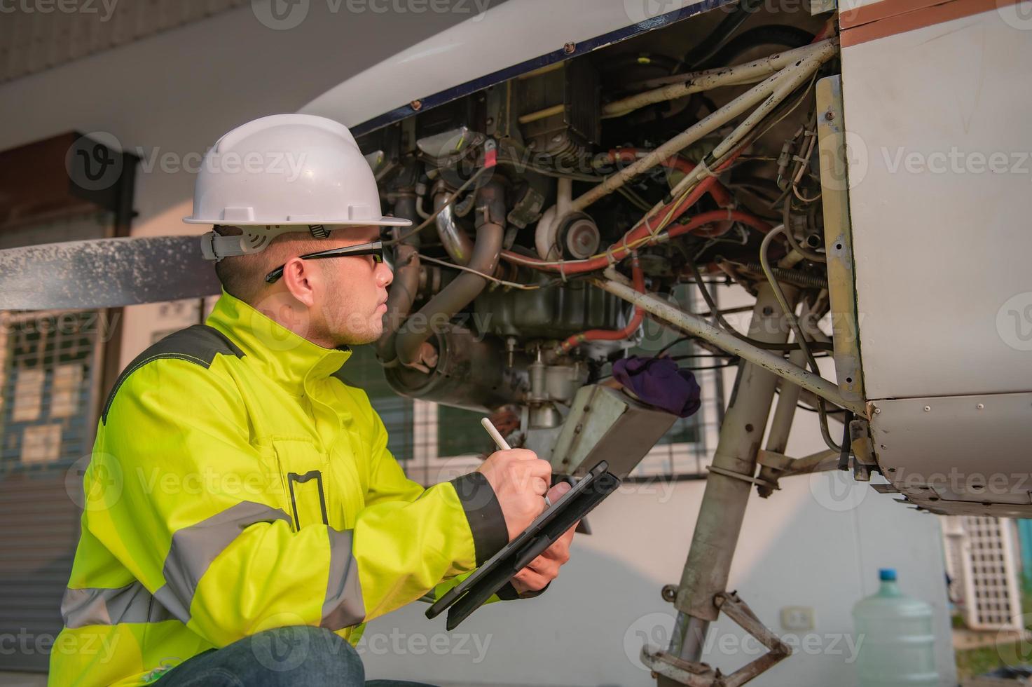 técnico consertando o motor do avião, engenharia aeroespacial masculina verificando motores de aeronaves, manutenção mecânica asiática inspeciona motor de avião foto