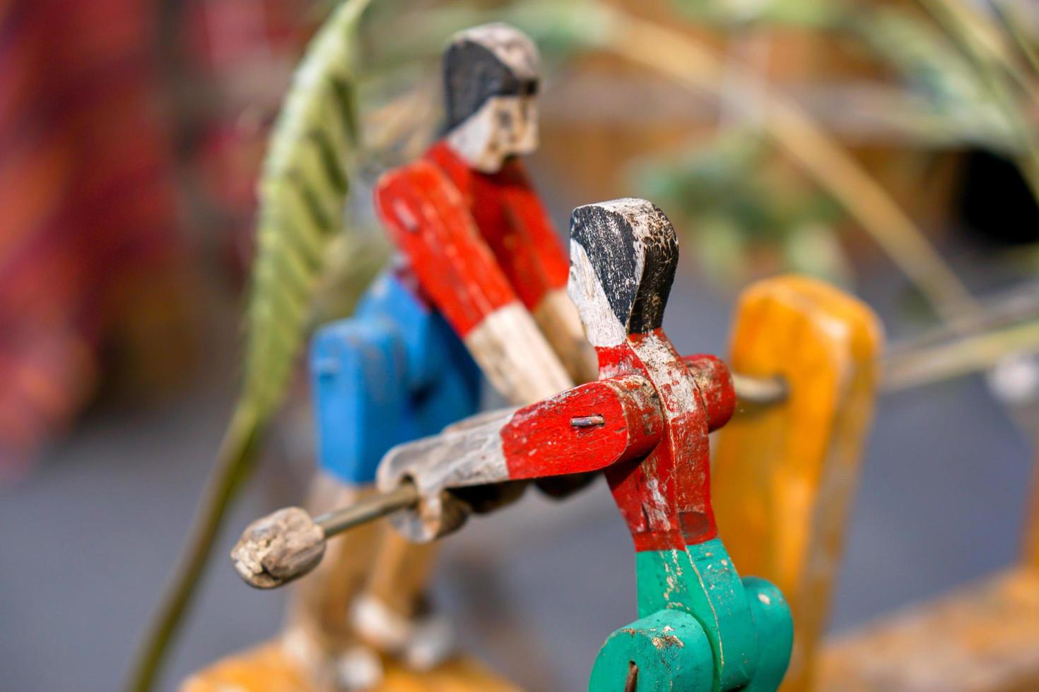 closeup brinquedo de madeira velho e antigo em humanos jogam gangorra no fundo desfocado. foto