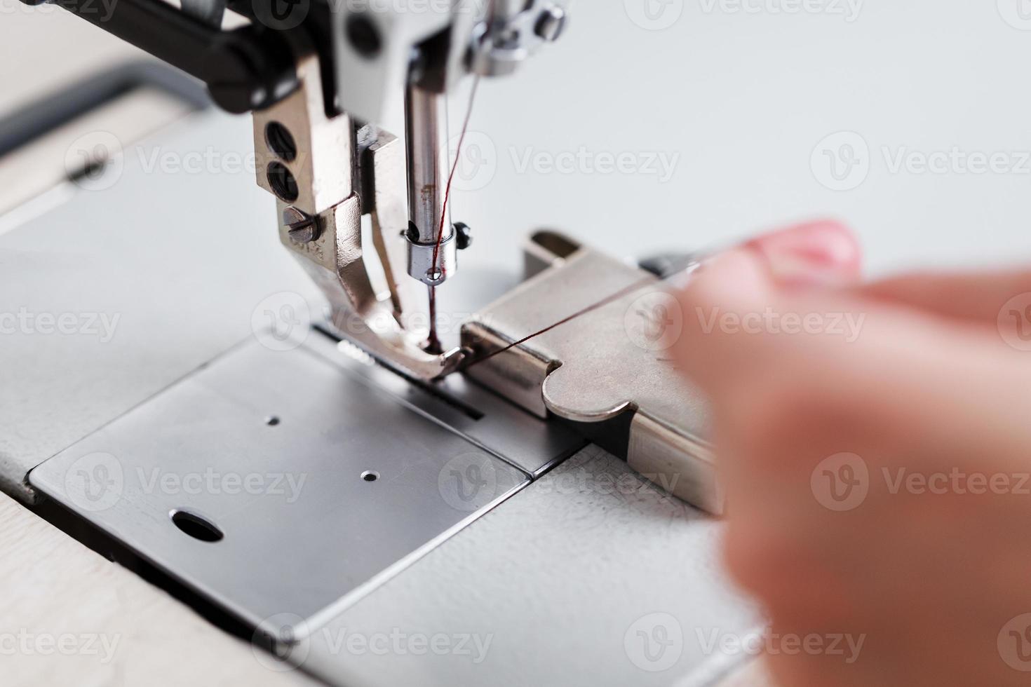 um artesão de couro produz artigos de couro em uma máquina de costura em sua loja. foto