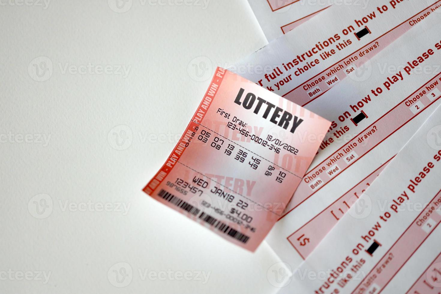 o bilhete de loteria vermelho encontra-se em folhas de jogo rosa com números para marcação para jogar na loteria. conceito de jogo de loteria ou vício em jogos de azar. fechar-se foto
