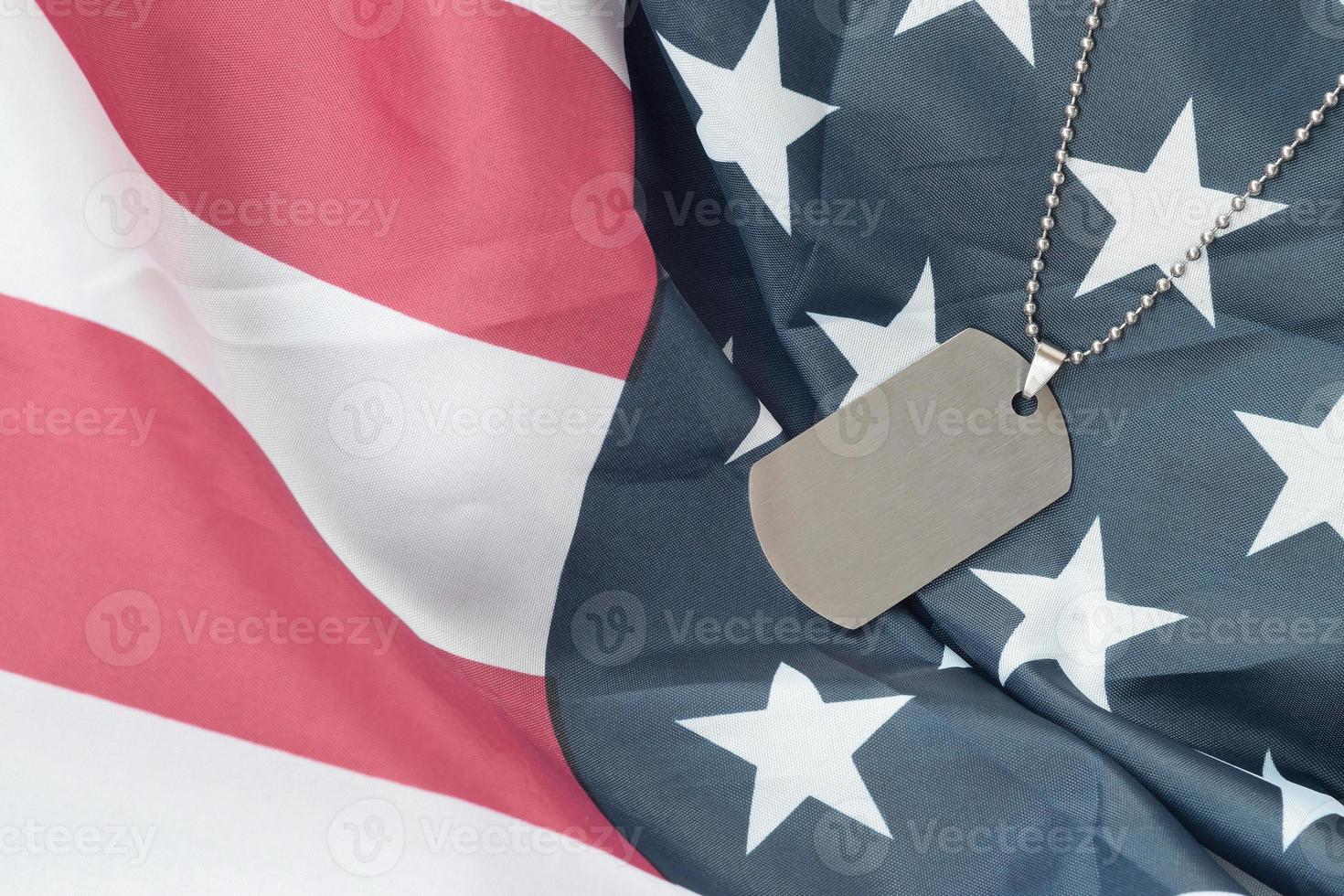 contas militares prateadas com placa de identificação na bandeira de tecido dos estados unidos foto
