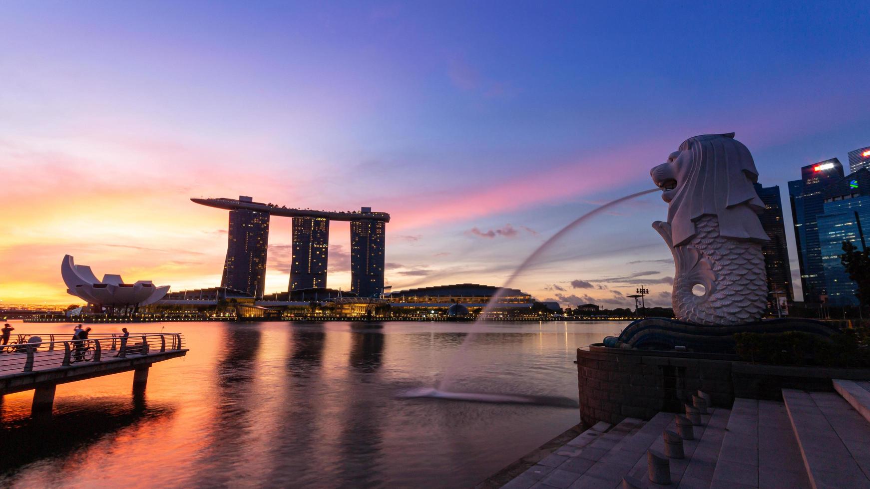 marina bay, singapore 15 de outubro de 2022 merlion e marina bay sands com crepúsculo da manhã. edifício icônico ao redor da baía da marina. foto