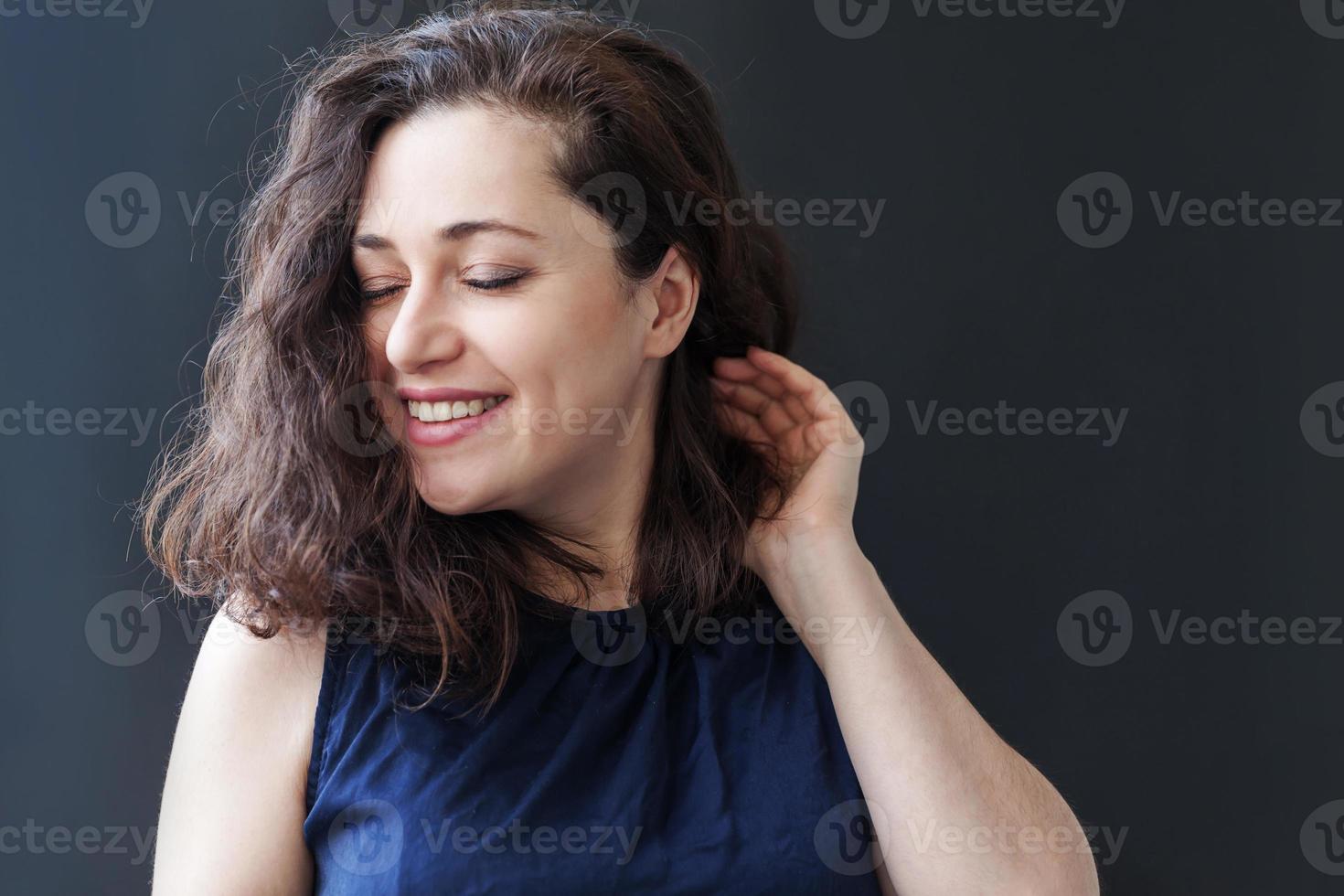 garota feliz sorrindo. beleza retrato jovem feliz positivo rindo morena em fundo preto isolado. mulher europeia. emoção humana positiva expressão facial linguagem corporal foto