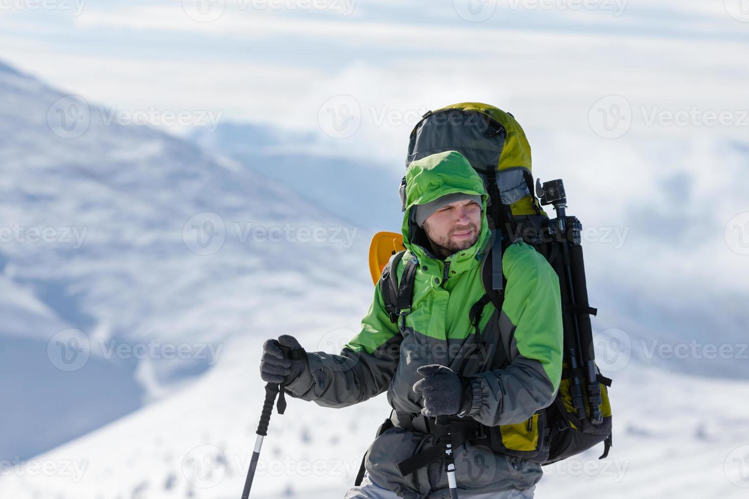 mochileiro posando em montanhas de inverno foto