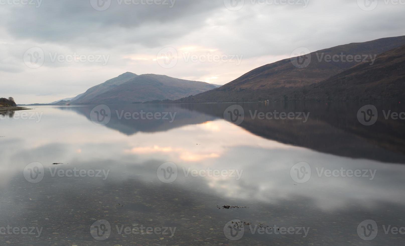 reflexos de montanha em um lago na Escócia foto