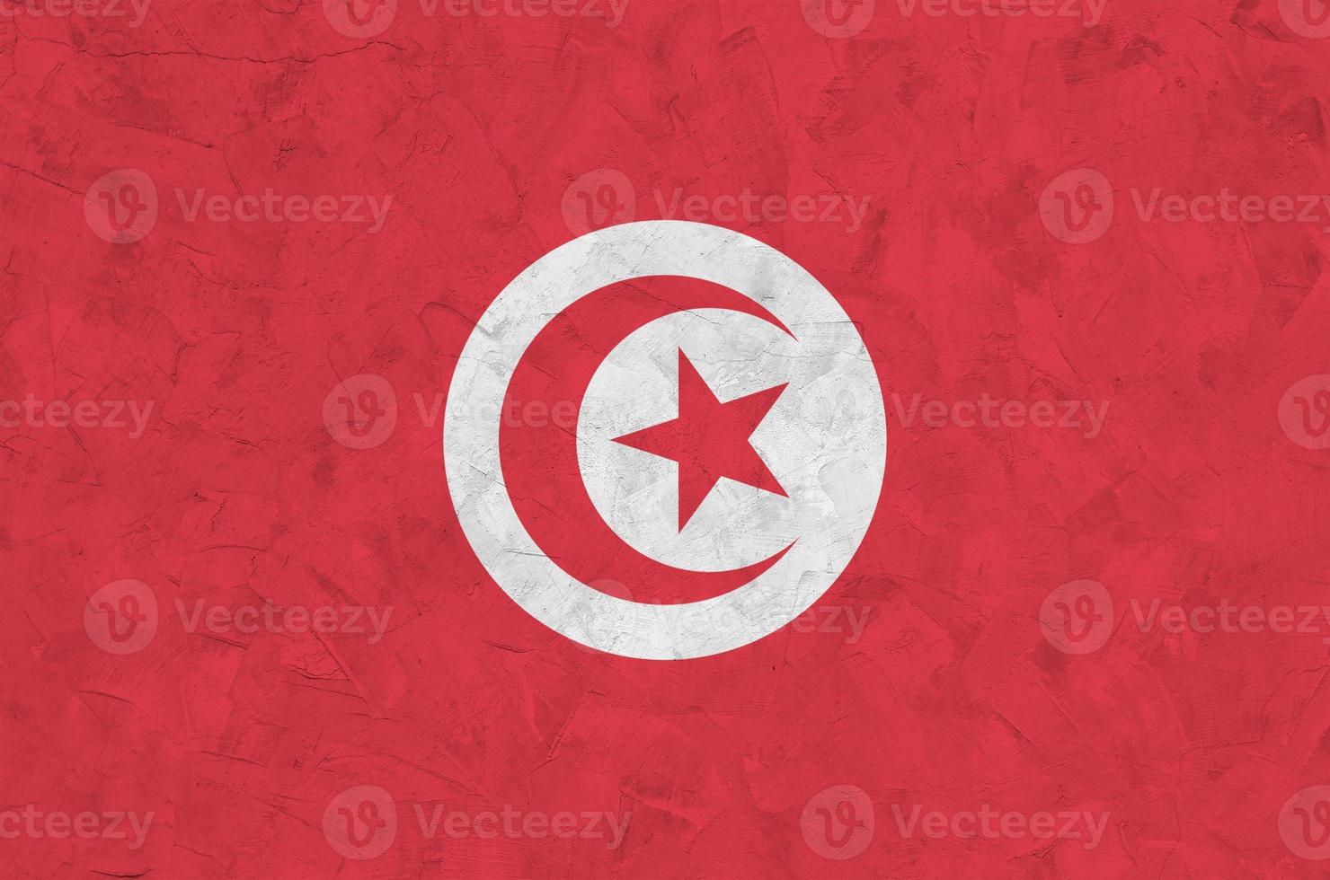 bandeira da tunísia retratada em cores de tinta brilhante na parede de reboco em relevo antigo. banner texturizado em fundo áspero foto