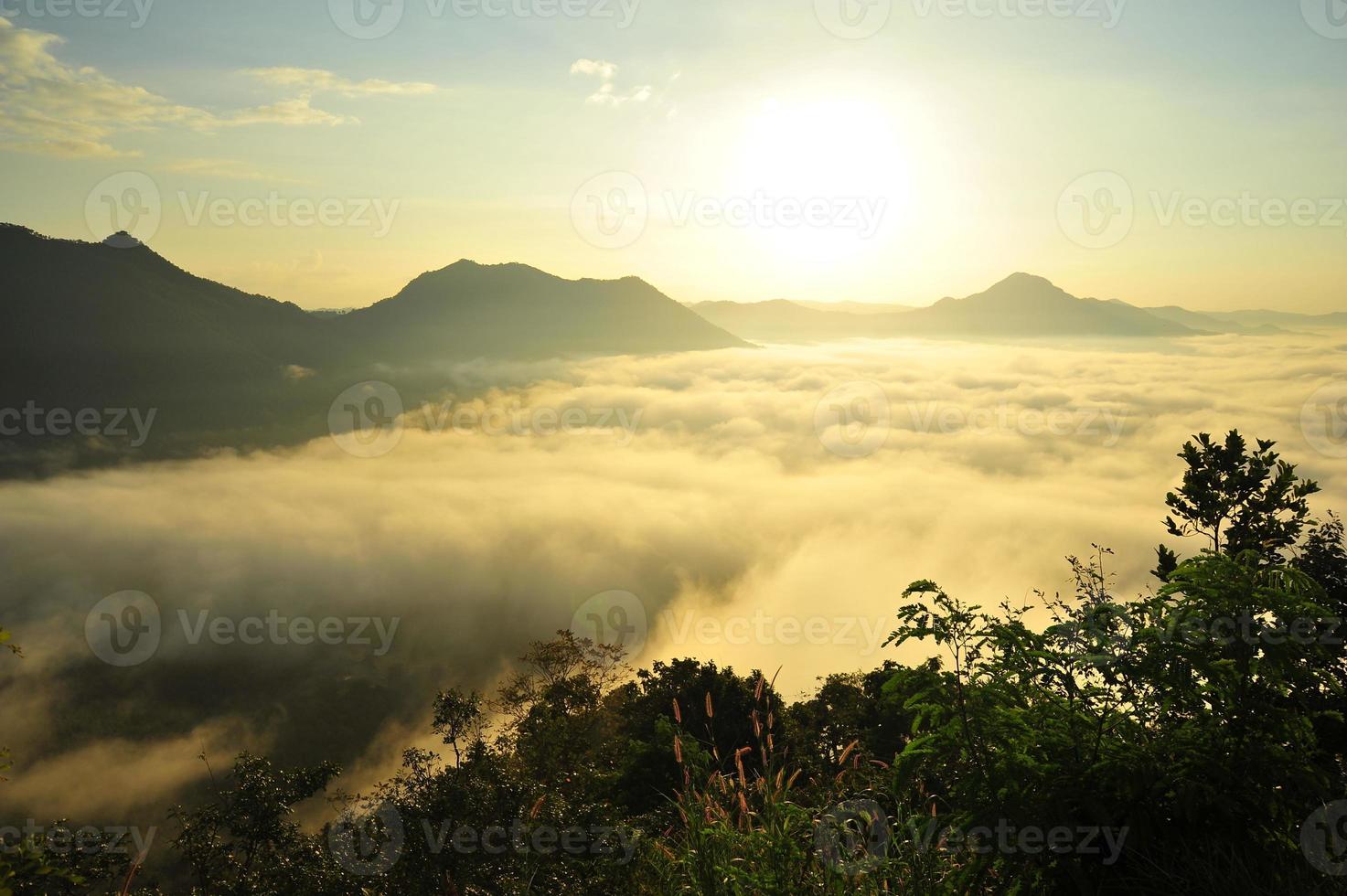 paisagem montanhosa no nevoeiro ao nascer do sol foto