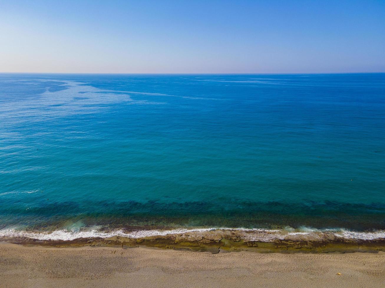 vista aérea do mar, vista de cima, fundo de natureza incrível. cor da água e lindo brilhante. costa rochosa e água clara do mar em um dia ensolarado voando drone, paisagem marinha foto