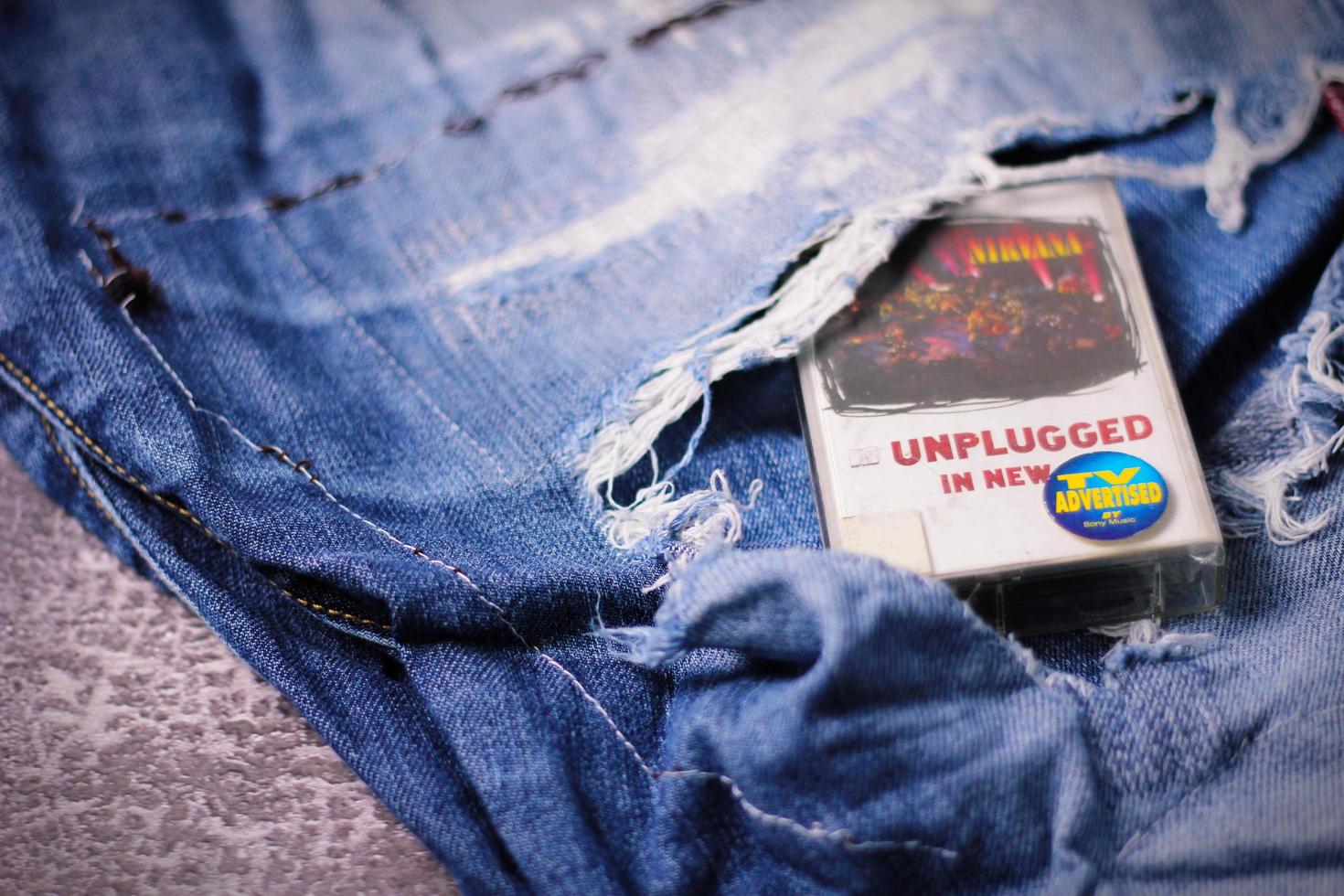 washington eua - 30 de setembro de 2022 fita cassete do nirvana e jeans rasgados ou jeans rasgados. um símbolo do som grunge ou de seattle. foto