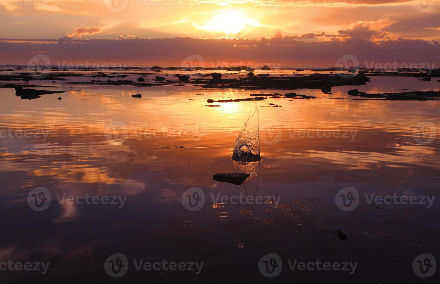 corte de seixo ao nascer do sol no recife de rocha do oceano foto