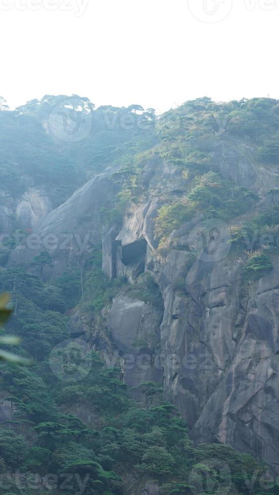 as belas paisagens das montanhas com a floresta verde e o penhasco rochoso em erupção como pano de fundo na zona rural da china foto