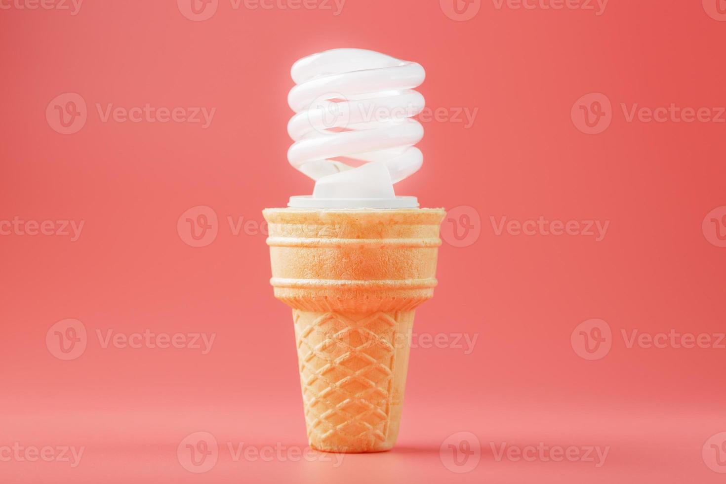 sorvete de luz de parafuso de economia de energia em um cone de waffle em um fundo rosa. foto