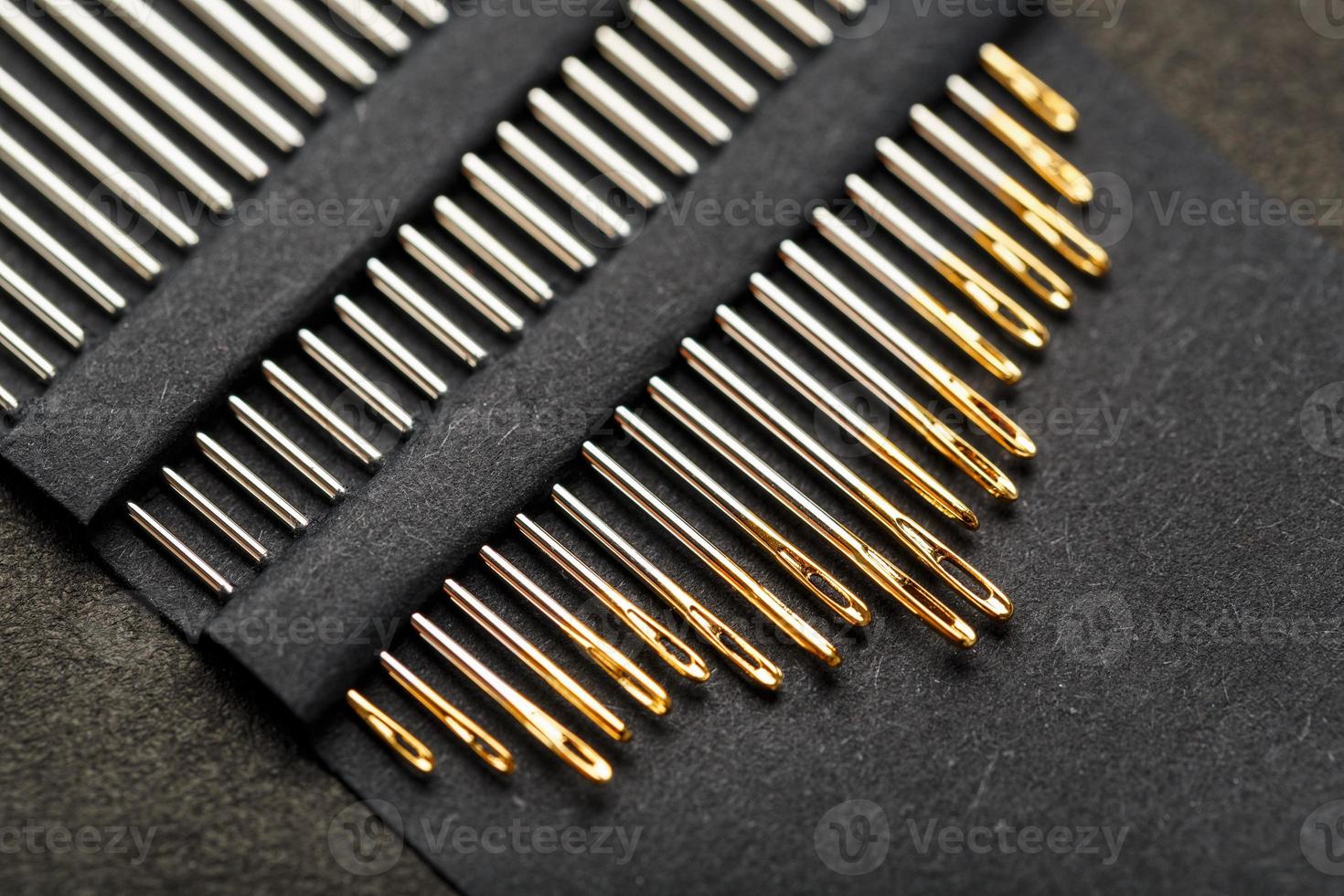 conjunto de agulhas de ouro em um fundo preto em uma fileira. foto