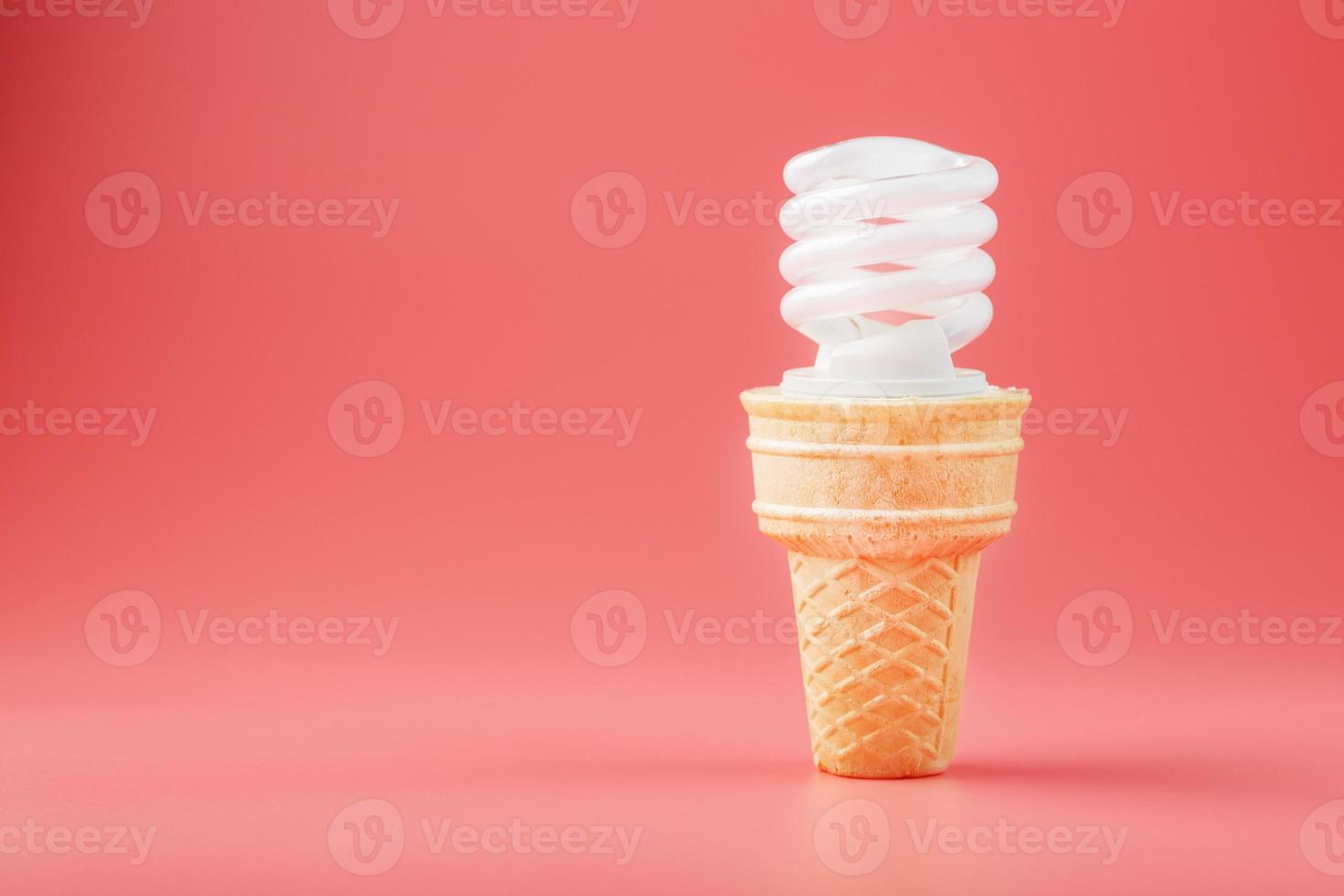 sorvete de luz de parafuso de economia de energia em um cone de waffle em um fundo rosa. foto