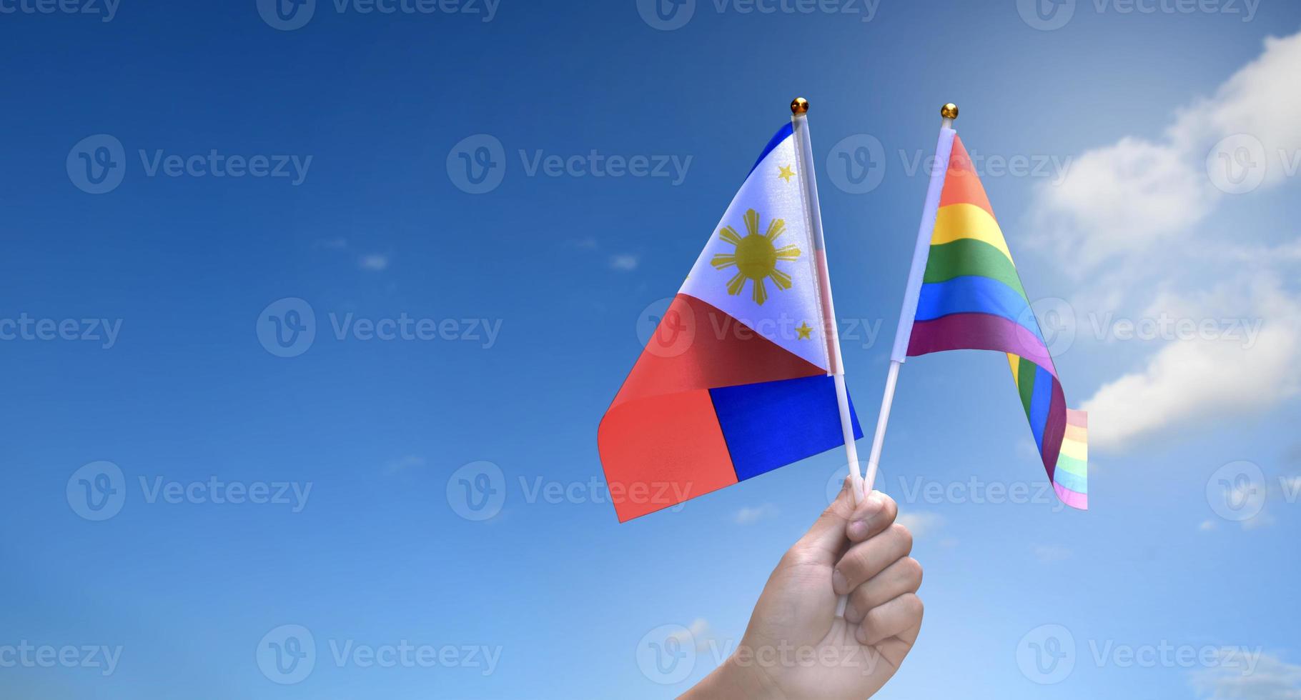 bandeira do arco-íris e bandeira nacional das filipinas segurando na mão, foco suave e seletivo, conceito para celebração do lgbtq no mês do orgulho em todo o mundo. foto