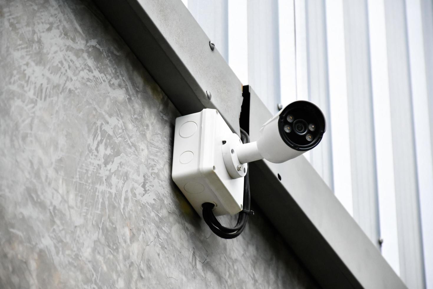 câmera ip cctv instalada no poste de madeira fora da casa para fazer a segurança monitorando através do telefone moblie e outros dispositivos inteligentes para salvar propriedades e vidas humanas. foto