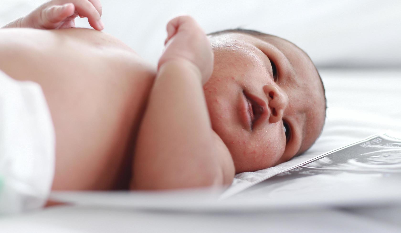 bebê recém-nascido está dormindo em uma cama de hospital. foto