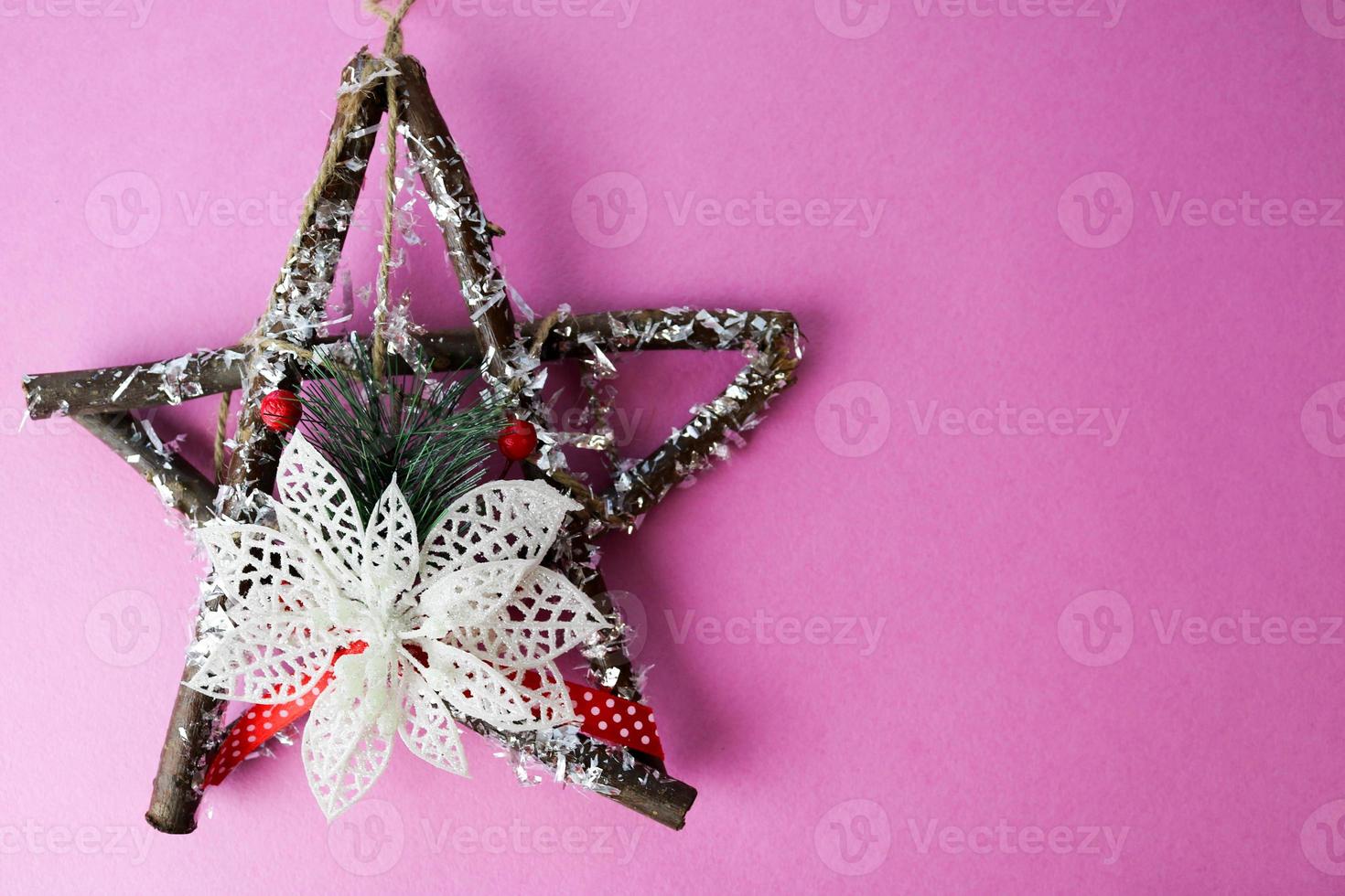 grande decorativa linda estrela de natal de madeira, uma coroa de advento self-made de ramos de abeto e varas sobre o fundo alegre rosa roxo feliz ano novo festivo. decorações de férias foto