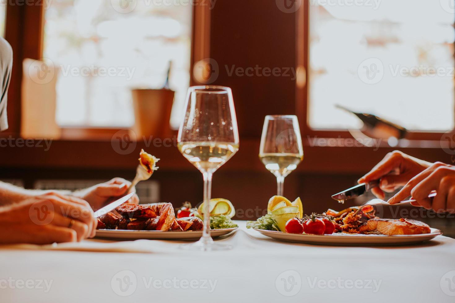 jovem casal almoçando com vinho branco no restaurante foto