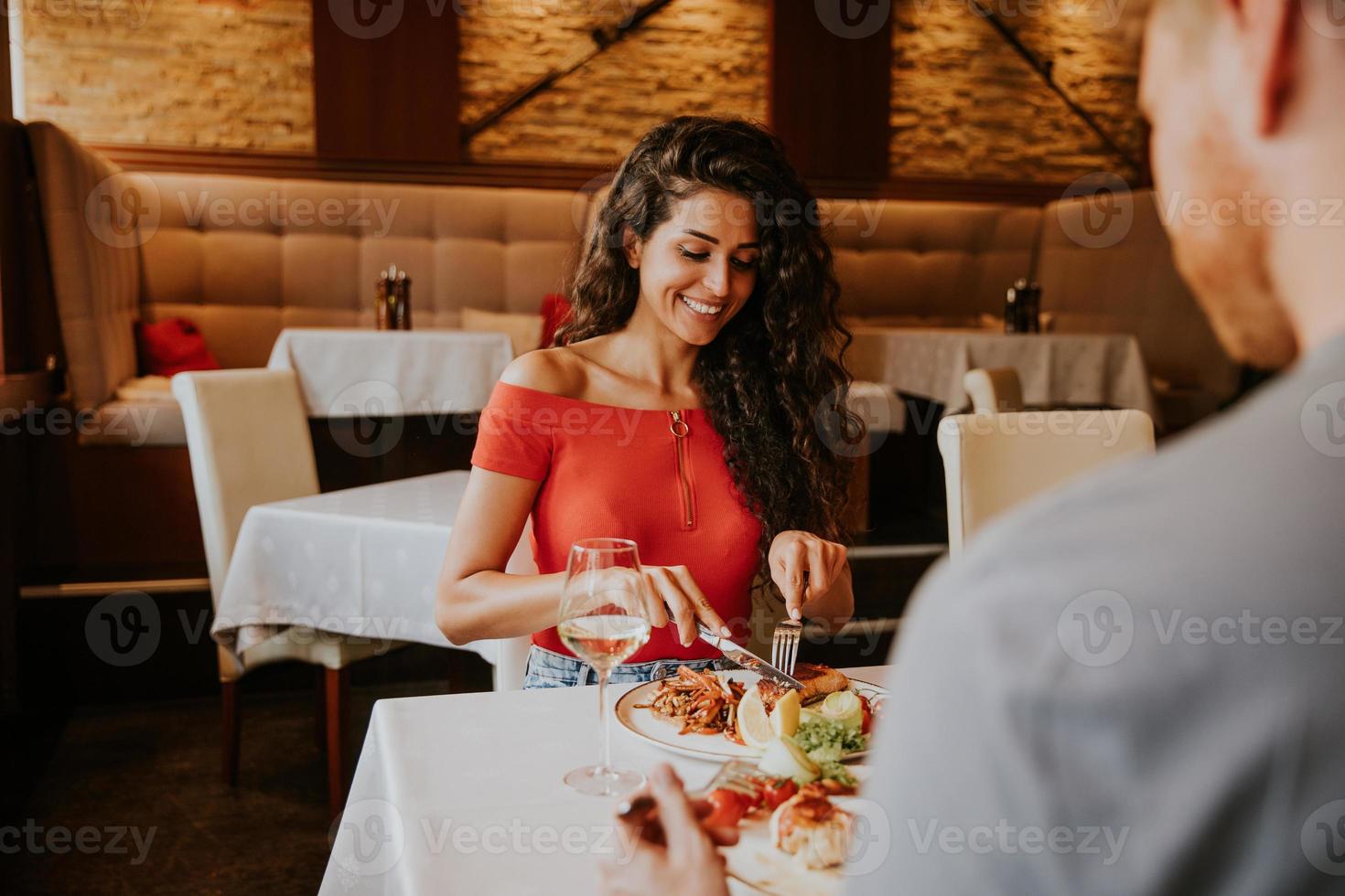 jovem casal almoçando com vinho branco no restaurante foto