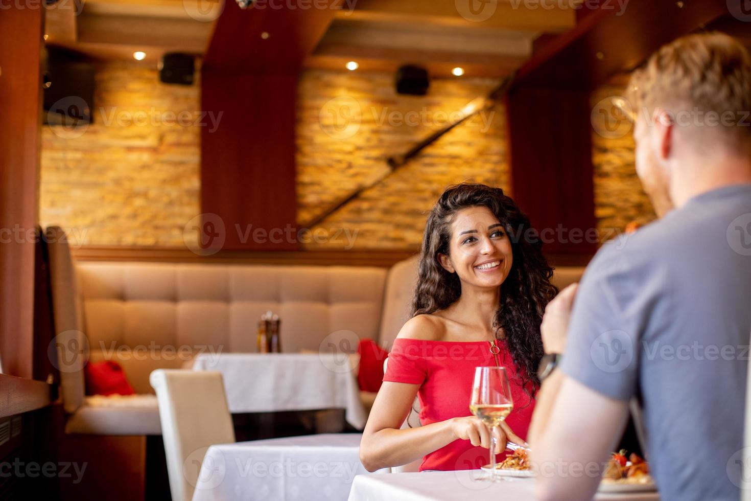 jovem casal almoçando com vinho branco no restaurante foto