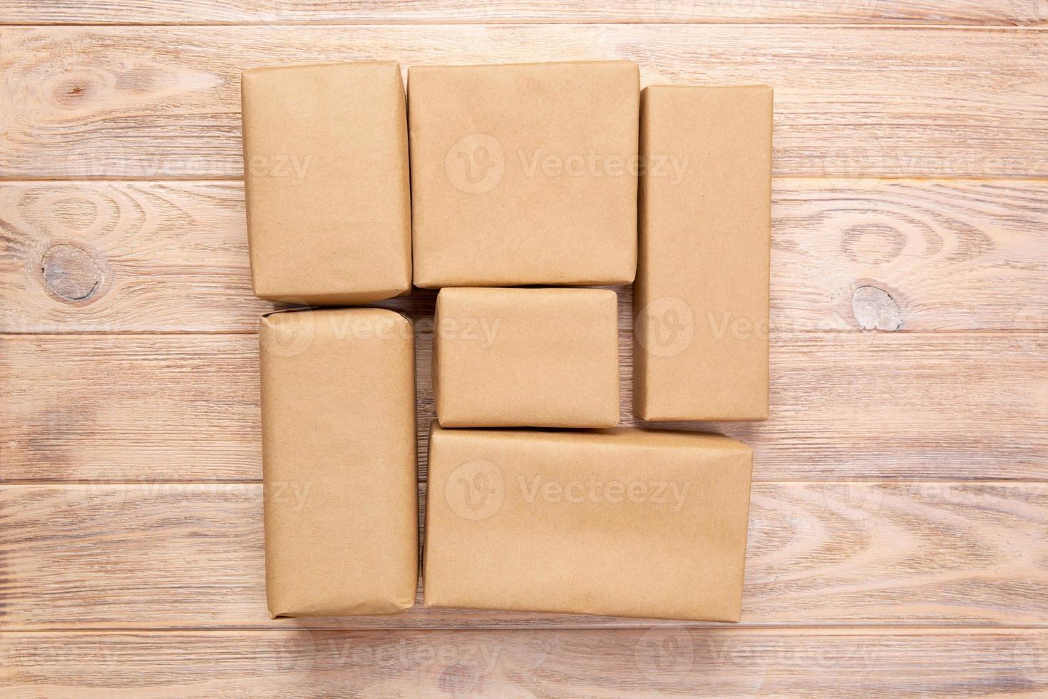 pacote de correio marrom em branco para você projetar. caixa de papelão em um fundo de madeira foto