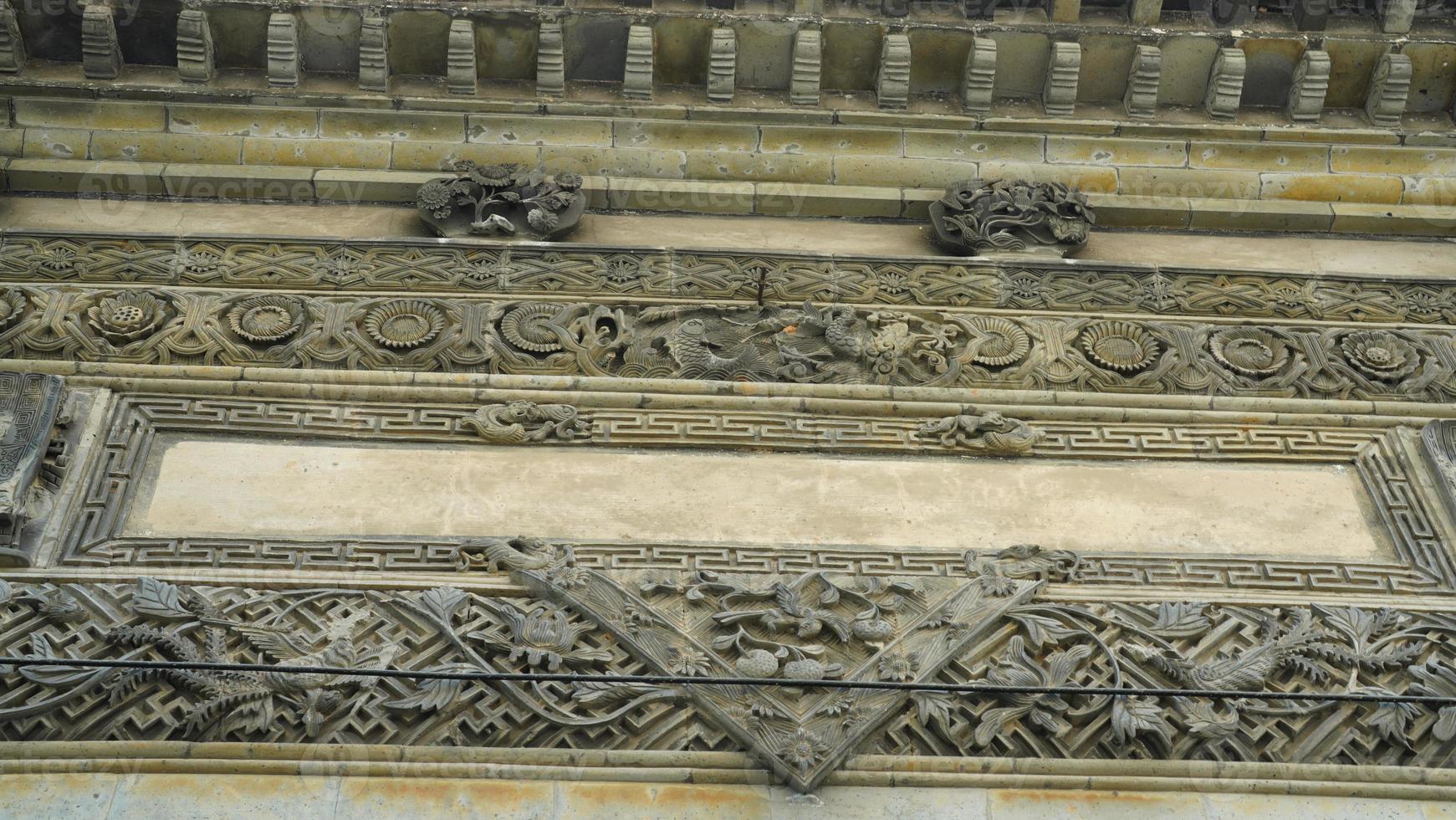 a antiga casa chinesa de pedra esculpida com a bela escultura na vila rural da china foto