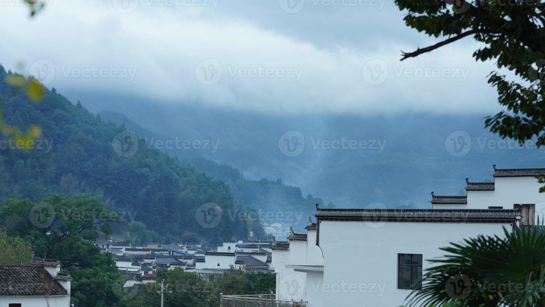 a bela vista da vila tradicional chinesa com a arquitetura clássica e árvores verdes frescas como pano de fundo foto