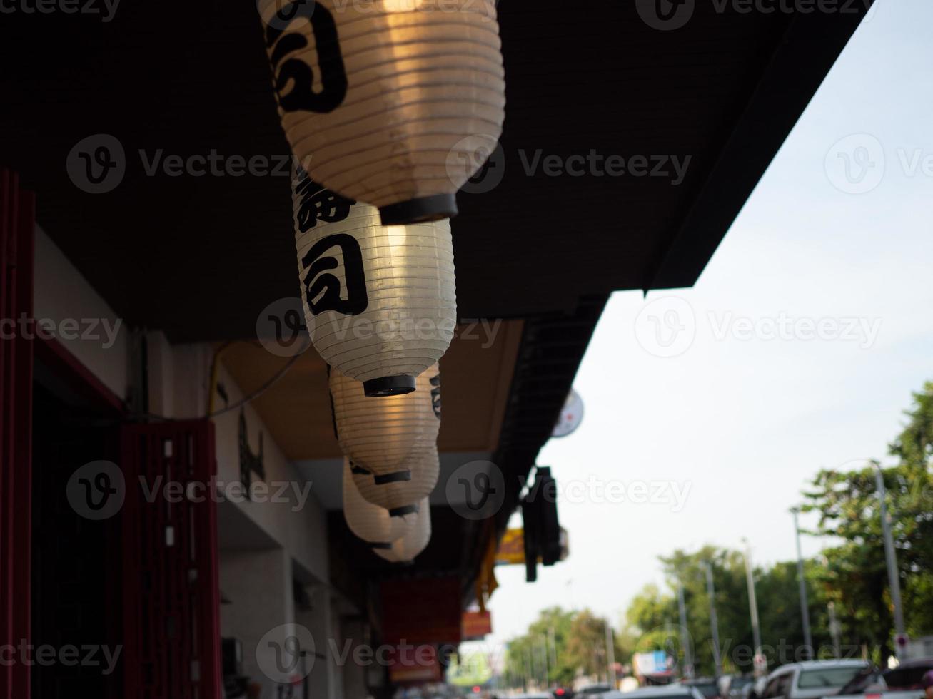 lanterna japonesa pendurada na frente do restaurante japonês, texto japonês na lanterna é comida japonesa de sushi. foto