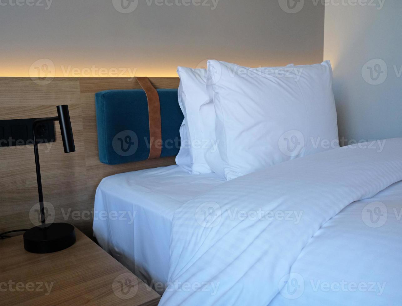 um fragmento de um quarto com um design de interiores moderno e aconchegante de uma casa ou hotel. travesseiro macio e cobertor, móveis elegantes e confortáveis. foto