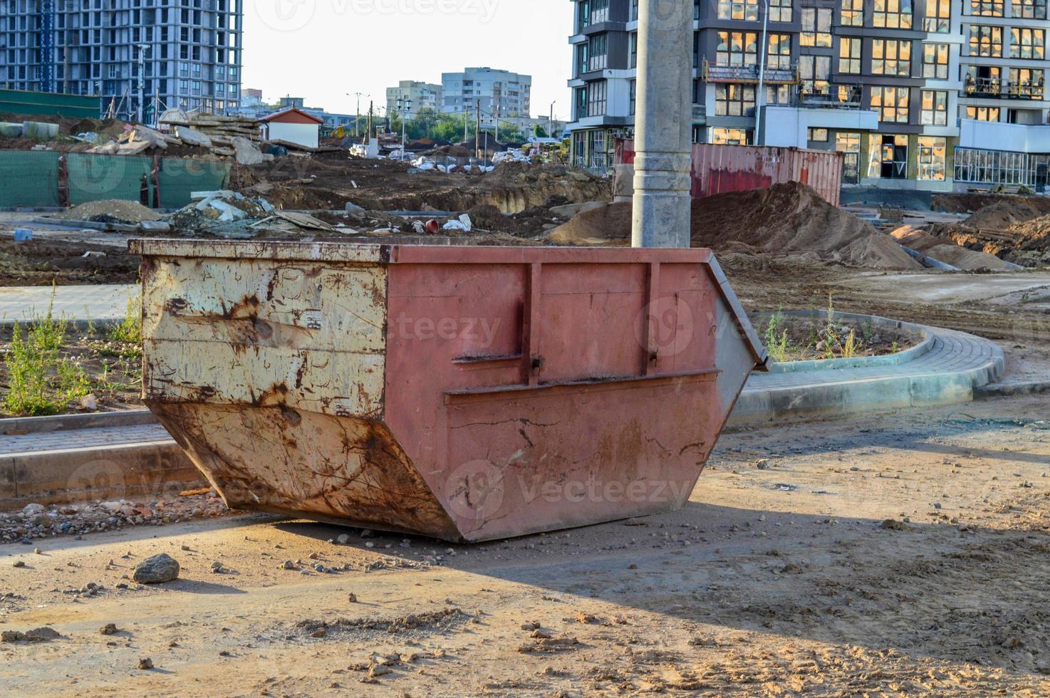 uma lixeira grande, enferrujada e rosa para resíduos de construção. um contêiner para coleta de lixo durante a construção de um grande complexo residencial no centro da cidade. coleta de cargas volumosas foto