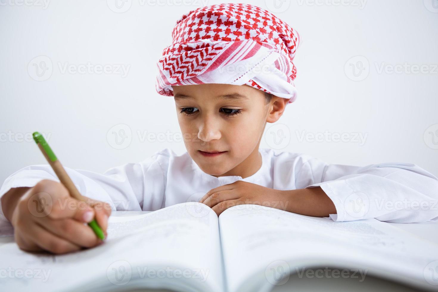 garotinho árabe fazendo lição de casa foto