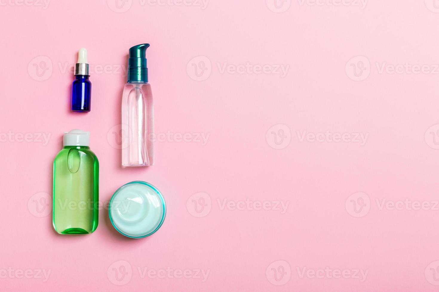 maquete de marca de spa de cosméticos, vista superior com espaço de cópia. conjunto de tubos e potes de creme deitado no fundo rosa foto