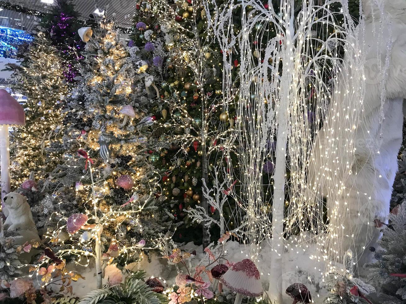 decorações de ano novo para o centro comercial. árvores de natal artificiais cobertas de neve. em um monte de neve ursos, esquilos e furões. véspera de Natal foto