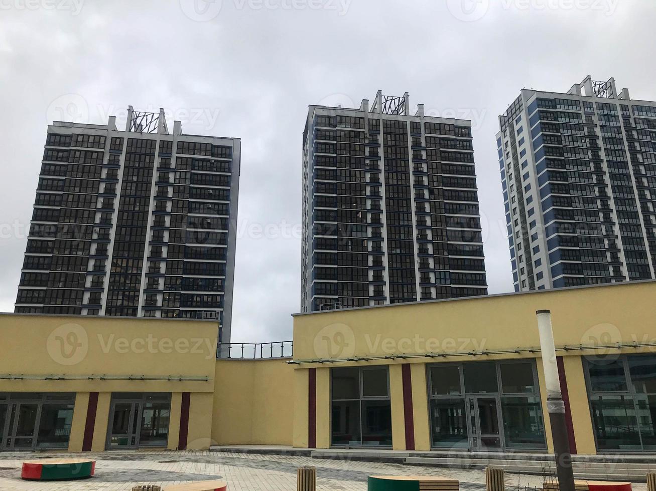 paisagem urbana, prédios de apartamentos em azul e branco. feito de vidro com janelas panorâmicas para ótima visualização. há um shopping center no centro do complexo foto