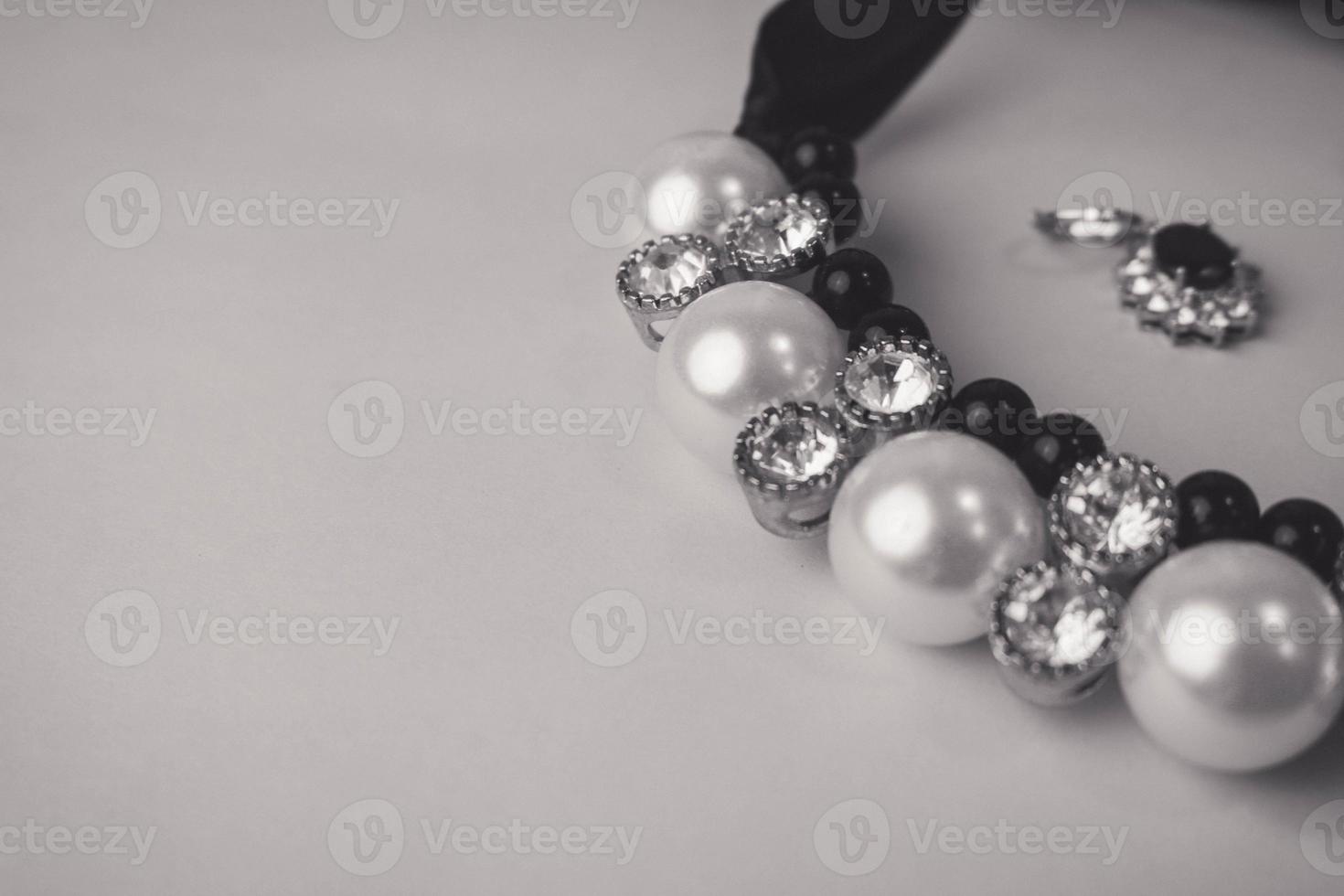 belas jóias preciosas preciosas brilhantes elegantes jóias glamourosas, colar e brincos com pérolas e diamantes, diamantes em um fundo preto e branco. configuração plana, vista superior, local de cópia foto