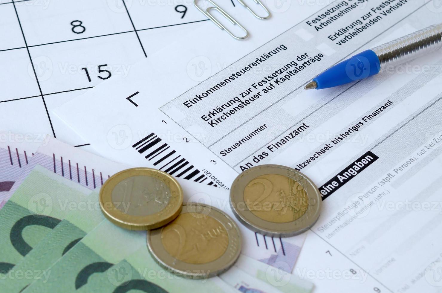 formulário de imposto alemão com caneta e contas de dinheiro europeias encontra-se no calendário do escritório. contribuintes na alemanha usando moeda euro para pagar impostos foto