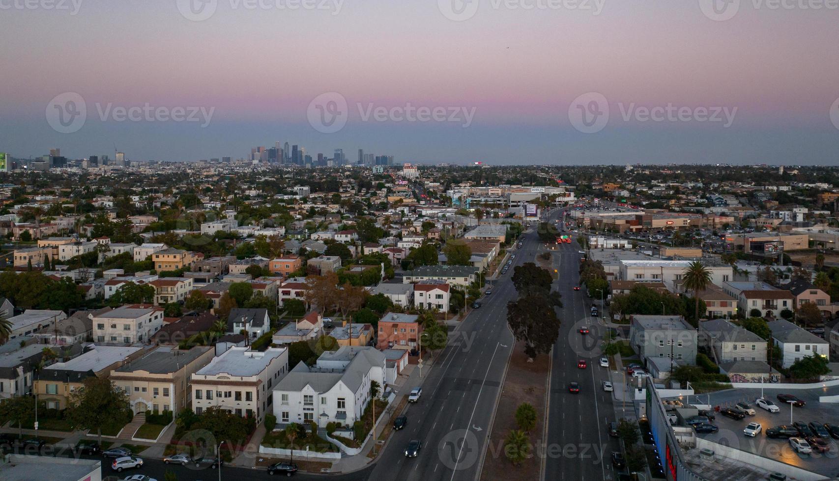 vista do pôr do sol quente de los angeles com palmeira e centro da cidade em segundo plano. foto