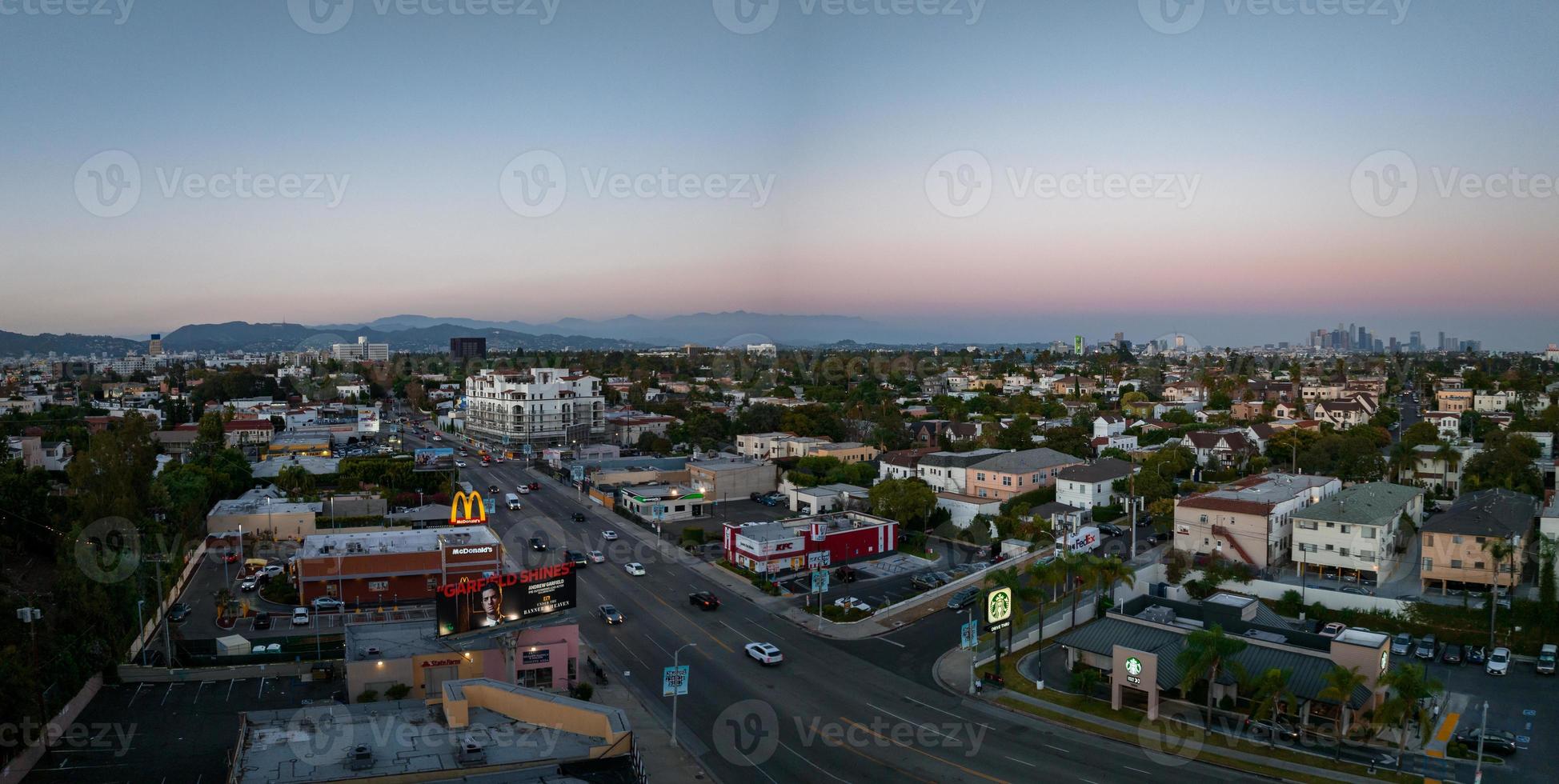 vista do pôr do sol quente de los angeles com palmeira e centro da cidade em segundo plano. foto