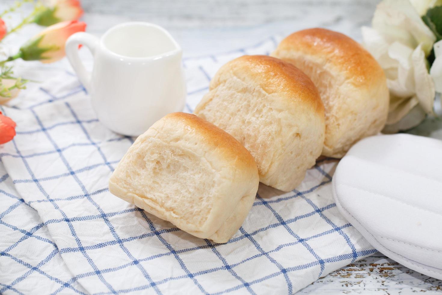 Pão fresco feito em casa no fundo da mesa branca foto