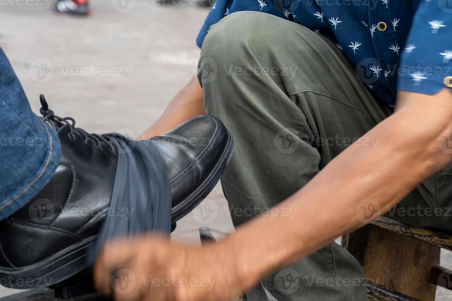 homem latino mais velho, pele escura, limpando e engraxando sapatos, feliz com sua profissão méxico foto